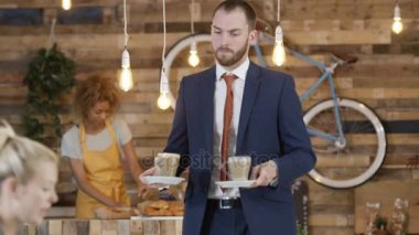 İş erkek ve kadın bir toplantı kafede içki servisi garsonla sahip.