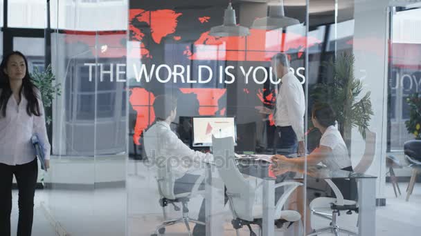 Team Business Una Riunione Guardando Mappa Del Mondo Con Slogan — Video Stock