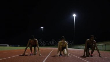 4 k rekabetçi kadın sporcular yarış pisti karanlıkta çalışan