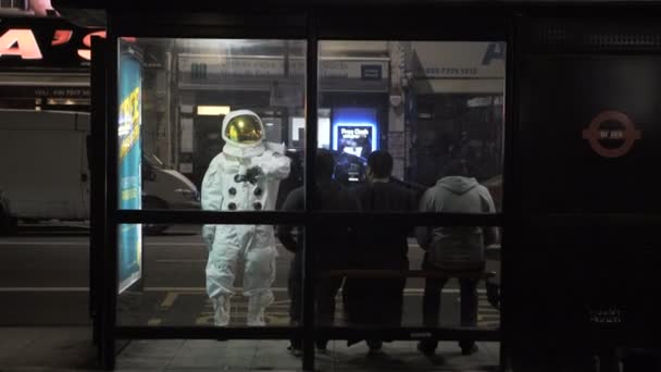 Astronauta Fora Serviço Esperando Parada Ônibus Uma Rua Cidade Noite — Vídeo de Stock