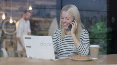 Bir kafede dizüstü kullanarak ve Evet genç kadın