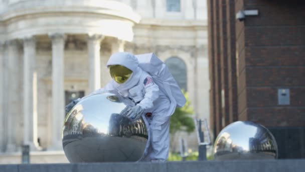 Astronauta Engraçado Retornou Terra Abraçando Escultura Esfera Metal Cidade — Vídeo de Stock