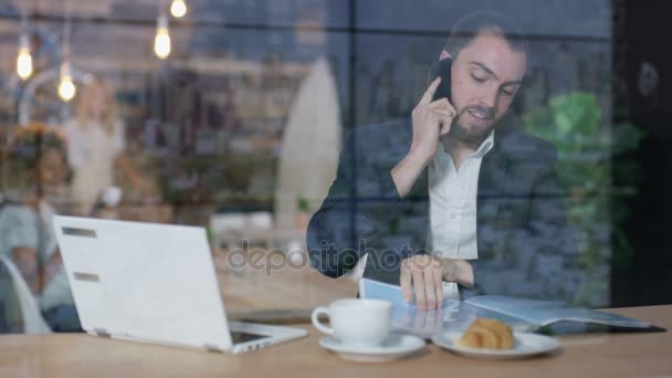 Joven Hombre Negocios Trabajando Ordenador Portátil Hablando Por Teléfono Cafetería — Vídeos de Stock