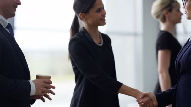 4K Portrait of smiling businesswoman shaking hands with colleagues in modern office