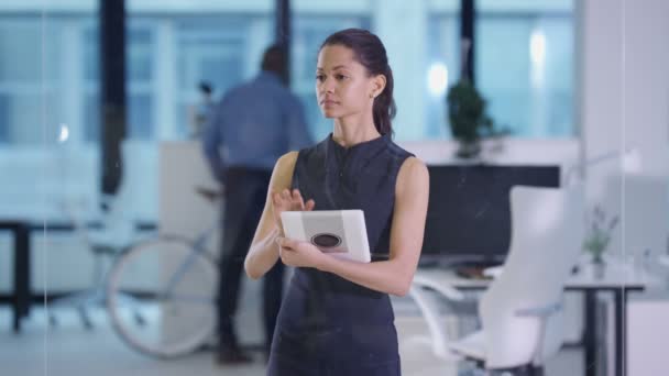 Femme d'affaires 4K dans le bureau moderne en utilisant une tablette et un écran interactif 