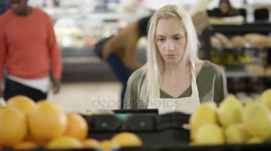 4k çalışan bir süpermarket tablet bilgisayar bakarak ve stok kontrol