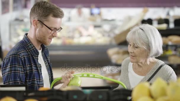 Kıdemli Bayan Süpermarkette Bakkaliye Satın Yetişkin Torunu — Stok video