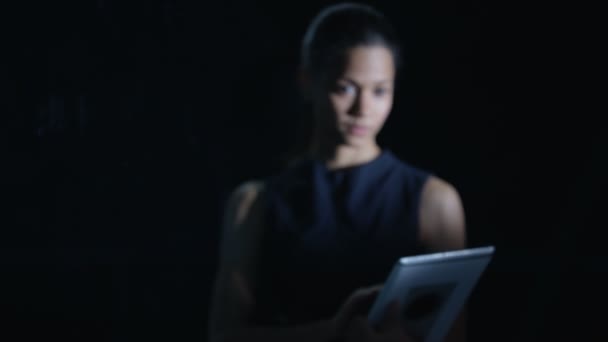 女性の黒い背景にコンピューターのタブレットとインタラクティブなタッチ スクリーンを使用して — ストック動画