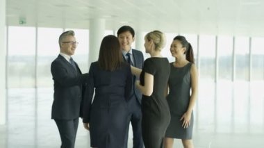 4 k iş takım tanışın ve büyük modern ofis binası içinde el sallamak