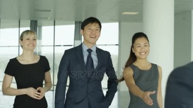 4 k iş takım tanışın ve büyük modern ofis binası içinde el sallamak