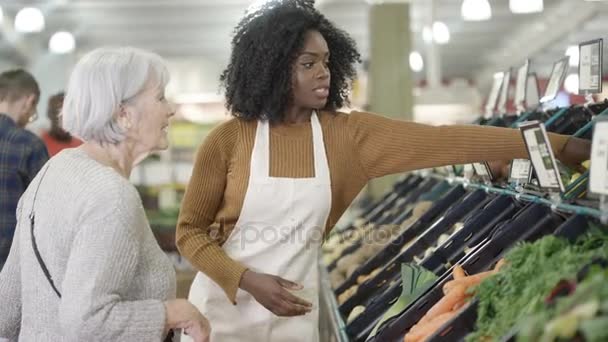 Дружелюбный Работник Супермаркете Помогающий Пожилой Женщине Покупать Продукты — стоковое видео
