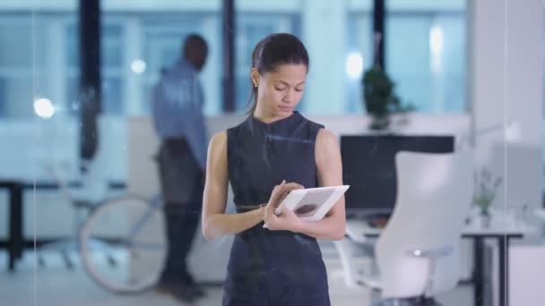 Femme d'affaires 4K dans le bureau moderne en utilisant une tablette et un écran interactif 