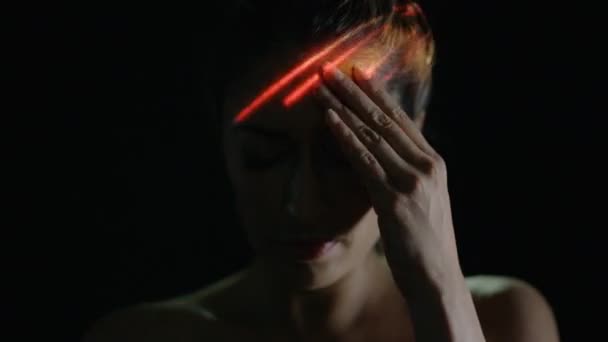 脳の活動または片頭痛を示す女性の顔に投影される光 — ストック動画