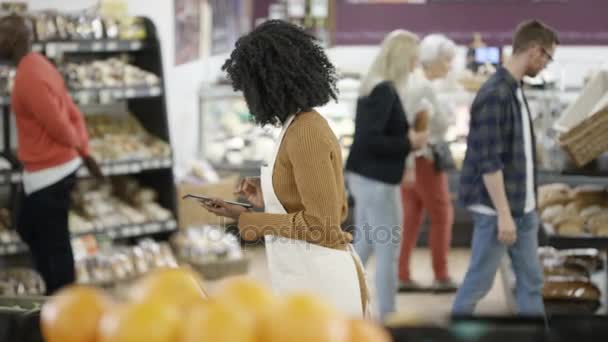 Trabalhador Supermercado Olhando Para Computador Tablet Verificando Estoque — Vídeo de Stock