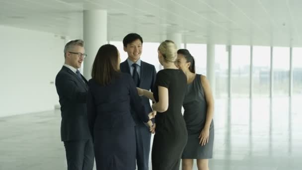 4 k obchodní týmy splňují a potřást rukou ve velké moderní kancelářská budova