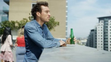 4k bira içip çatı partisi manzaraya bakarak gülümseyen adam portresi