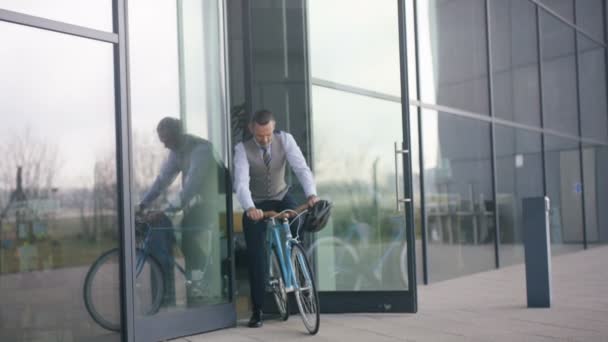 Porträt Eines Fröhlichen Geschäftsmannes Der Bürogebäude Auf Dem Fahrrad Verlässt — Stockvideo