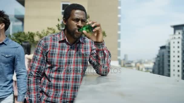 Retrato Homem Sorridente Bebendo Cerveja Olhando Para Vista Festa Telhado — Vídeo de Stock