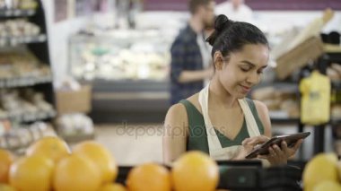 Tablet bilgisayar ile gülümseyen bakkal işçisi 4k portresi