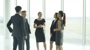 4 k çekici karışık etnik iş takım büyük modern ofisinde konuşmak