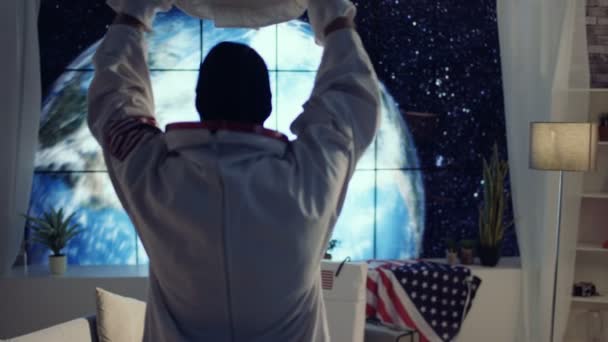 Astronaute 4K dans un appartement avec vue sur la planète Terre se préparant pour une mission 