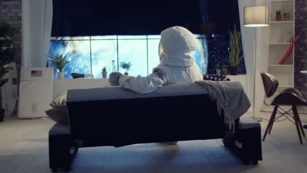 Astronaute Relaxant Dans Appartement Avec Vue Sur Planète Terre — Video