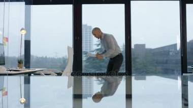 Tek başına çalışan bir kahve ile işadamı bakarak trendy, cam modern ofis gazetelerde büyük pencereler ile.