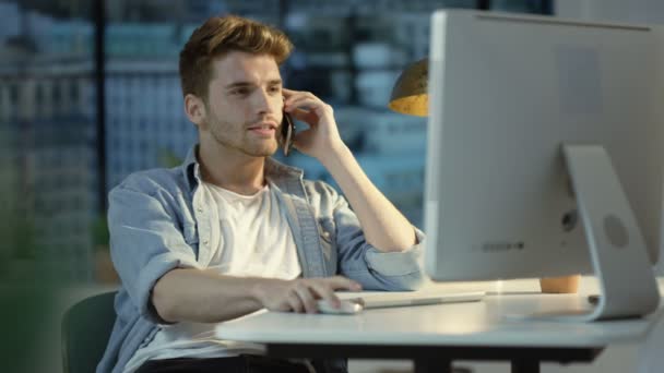 Hombre Joven Usando Ordenador Hablando Por Teléfono Celular Apartamento Ciudad — Vídeo de stock