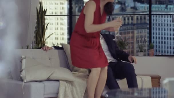 时尚的年轻夫妇放松和喝香槟在公寓与纽约的背景下的建筑物 — 图库视频影像