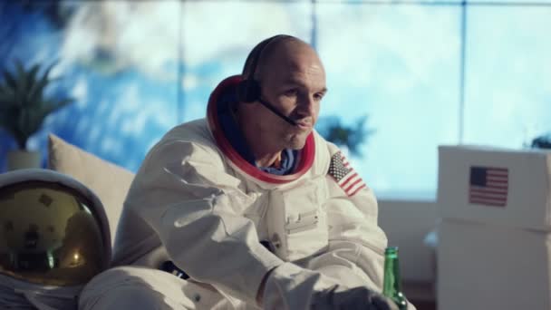 宇航员在公寓里放松 看电视 喝啤酒 — 图库视频影像