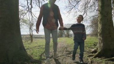 4 k mutlu genç Asyalı baba ve oğul güneşli bir günde ormanda bir yürüyüşe