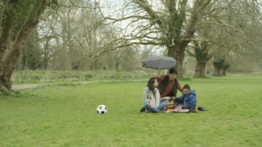 4 k mutlu Asya aile piknik şemsiye yağmur yağmaya başlayan olarak koyarak