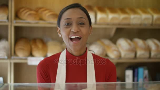 カウンターで顧客に役立つベーカリー ショップで のフレンドリーな労働者 — ストック動画