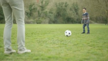 4 k mutlu genç Asyalı baba ve açık havada futbol oynayan ve having fun