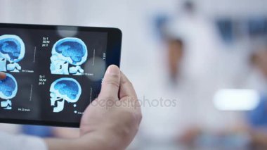 4 k tıbbi ekip bir toplantı. Tablet beyin taraması ile ön planda tutan eller