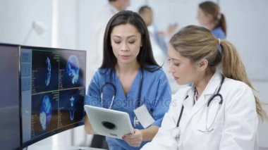 4 k tıbbi ekip modern kliniğinde hasta taramalar bilgisayar ekranlarında arıyorsunuz
