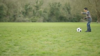 4 k mutlu genç Asyalı baba ve açık havada futbol oynayan ve having fun