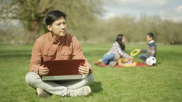 Homme Travaillant Sur Ordinateur Portable Dans Parc Avec Mère Fils — Video