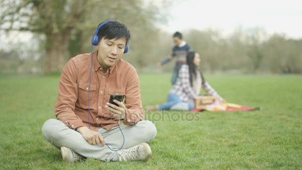 Man Luisteren Naar Muziek Het Park Met Moeder Zoon Achtergrond — Stockvideo