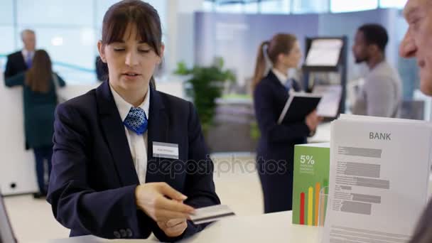 Bank Werknemer Servicedesk Klant Met Een Cash Terugtrekking Assisteren — Stockvideo