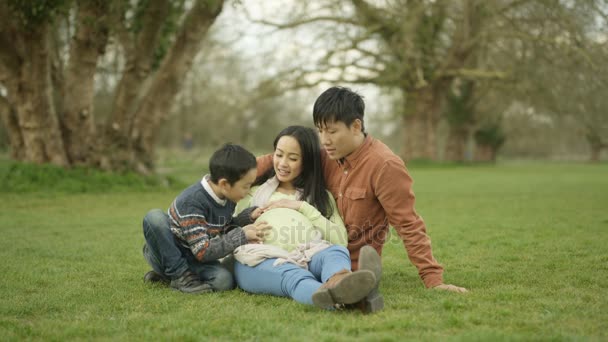 Счастливая Семья Отдыхает Парке Родители Ожидают Ребенка Симпатичным Маленьким Мальчиком — стоковое видео