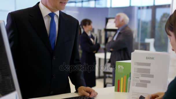 Trabalhador Bancário Balcão Serviço Que Ajuda Cliente Com Uma Retirada — Vídeo de Stock