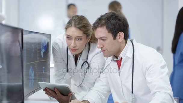 Ιατρική Ομάδα Στην Σύγχρονη Κλινική Εξέταση Ασθενούς Σαρώνει Στις Οθόνες — Αρχείο Βίντεο