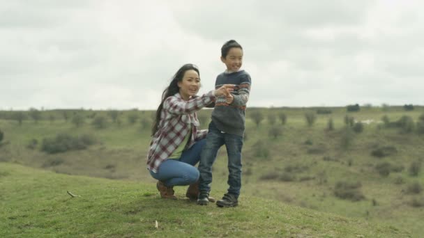 幸せな若い母と屋外の田舎で余暇を過ごす息子 — ストック動画