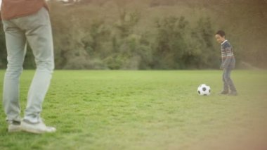 4 k mutlu genç Asyalı baba ve açık havada futbol oynayan ve having fun