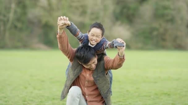 田舎屋外で彼の肩の上の息子を運ぶ幸せの父 — ストック動画