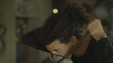 maske ve sprey ile 4 k grafiti sanatçısı kentsel alanda bir duvar üzerinde çalışıyor olabilir