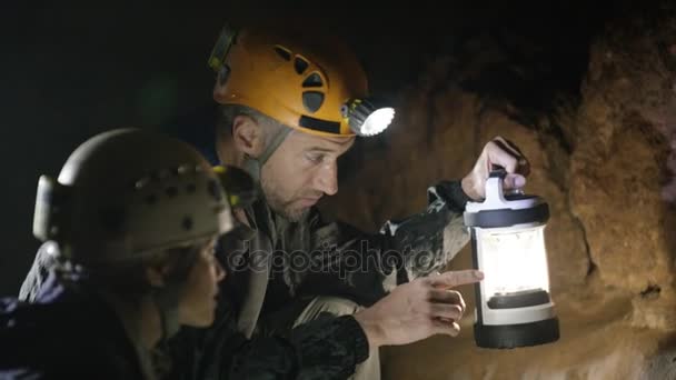 Geolog Menjelajahi Gua Bawah Tanah Membahas Formasi Batuan — Stok Video