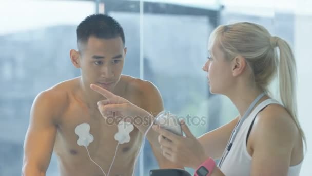 Male Athlete Exercise Bike Being Tested Monitored Sports Scientist — Stock Video