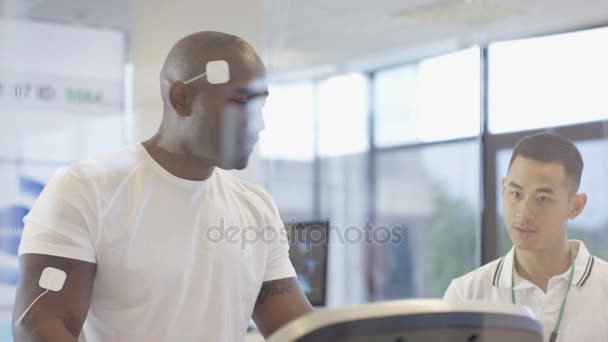 Afrikanisch Amerikanischer Mann Auf Laufband Wird Vom Sporttrainer Getestet Und — Stockvideo